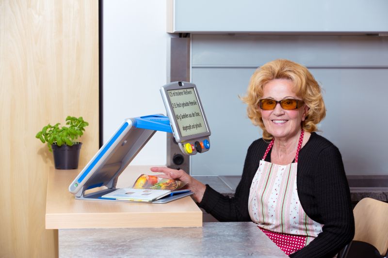 Dame in Küche mit Lesegerät und Kantenfilterbrille